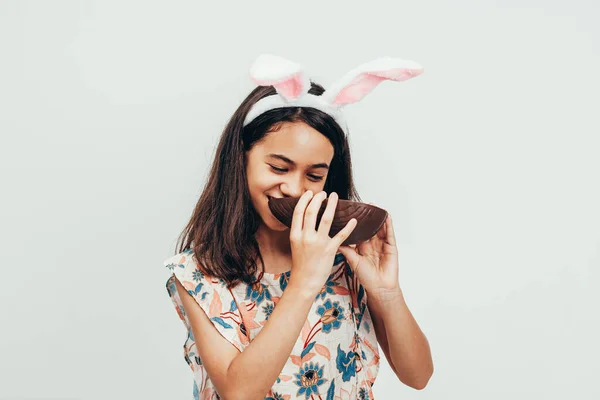 Sweet Little Girl Wearing Bunny Ears Eating Chocolate Easter Egg — Stock Photo, Image