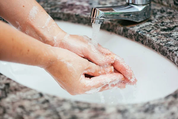 バスルームの洗面台で石鹸と水で手を洗う女性 コロナウイルスとCovid 19の予防 — ストック写真