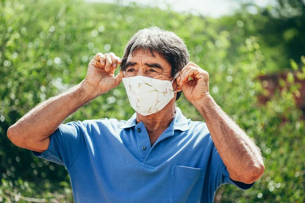 検疫中に自家製の保護マスクの日焼けを身に着けている高齢者の肖像画 コロナウイルス Covid パンデミックの概念 — ストック写真