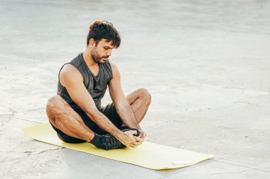 Egzersiz paspası üzerinde uzanan bir adam.