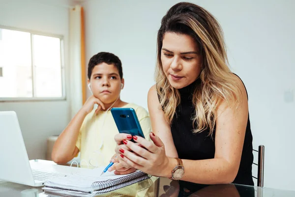 Mother Using Cell Phone Ignoring Her Son While Doing Homework — Stock Photo, Image