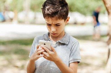 Dışarıdaki hücreyi kullanarak ciddi bir ifade takınan çocuk.