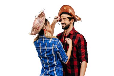 Festa Junina - Haziran festivali için geleneksel kıyafetler giyen Brezilyalı çift. Kadın ortağına makyaj yapıyor..
