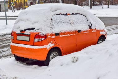 turuncu küçük araba beyaz karla kaplı. 