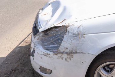 Beyaz araba kazası aracı yok edildi. Farlar bant ve plastik torbayla mühürlenmiş.