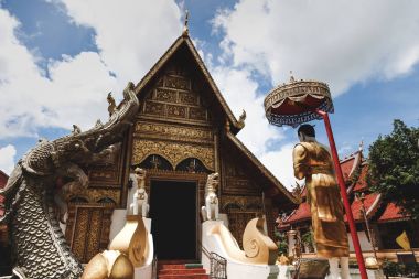 wooden thai temple with traditional hindu sculptures clipart