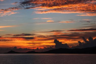 beautiful orange clouds on blue sky over evening seascape clipart