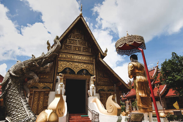 wooden thai temple with traditional hindu sculptures