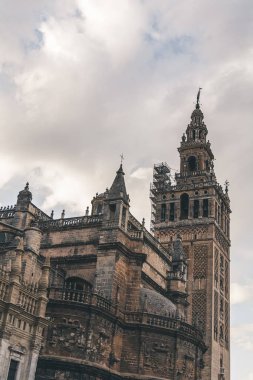 old gothic Seville Cathedral under cloudy sky, spain clipart