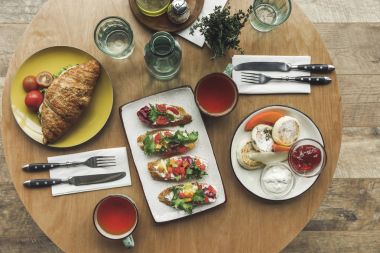 tabloda çay bardaklarından, sandviç ve cheesecakes üstten görünüm için kahvaltı