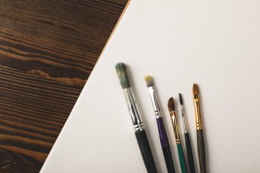 ahşap masa üzerinde Boya fırçaları ve boş çizim albüm Üstten Görünüm 