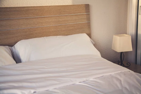 Hotel room interior with bed and lamp — Stock Photo