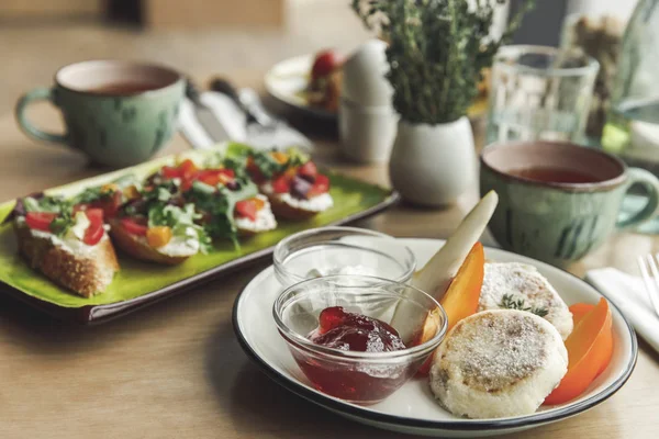 Vue rapprochée de délicieux gâteaux au fromage avec confiture et sandwichs pour le petit déjeuner — Photo de stock