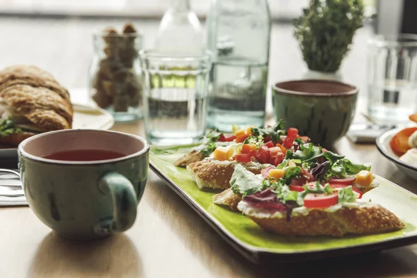 Close-up view of gourmet healthy breakfast with sandwiches and tea served on table — Stock Photo