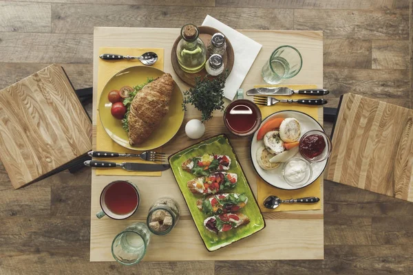 Top view of tasty healthy breakfast with cheesecakes and sandwiches on table — Stock Photo