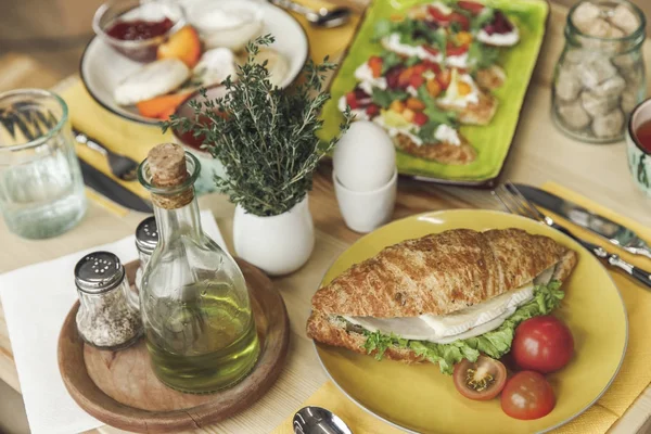 Vista de cerca de sabroso desayuno saludable con sándwich y huevo hervido en la mesa - foto de stock