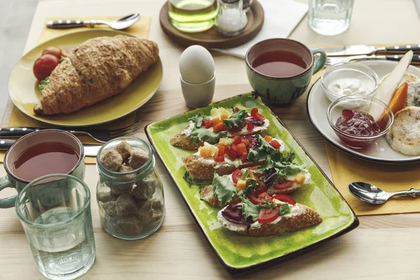 Close-up view of fresh tasty sandwiches and breakfast on table — Stock Photo