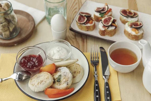 Vue rapprochée de savoureux petit déjeuner sain avec beignets de cheesecakes et confiture sur la table — Photo de stock