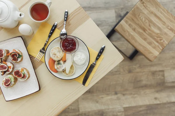 Blick von oben auf gesundes leckeres Frühstück mit Tee-Set auf Holztisch — Stockfoto