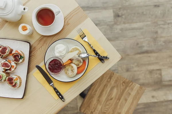 Вид зверху смачний здоровий сніданок з чайним набором на дерев'яному столі — стокове фото