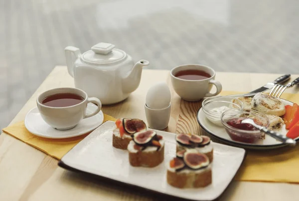 Tasty healthy breakfast with tea set on wooden table — Stock Photo