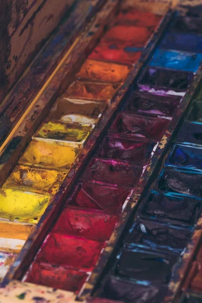 Close-up view of watercolor paints in messy container — Stock Photo