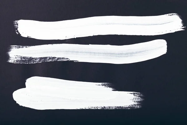 Абстрактний живопис з білими пензликами на чорному — стокове фото