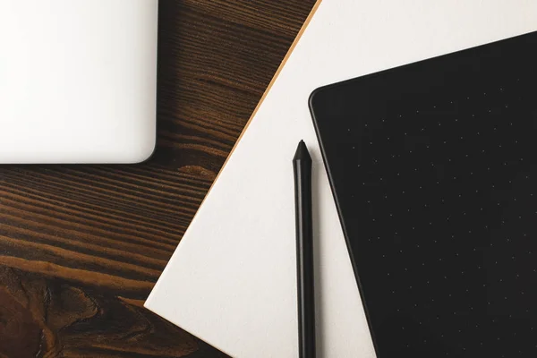 Top view of graphics tablet, laptop and drawing album on wooden table — Stock Photo