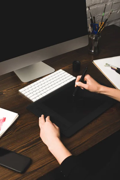 Cropped shot of designer using graphics tablet at workplace with desktop computer — Stock Photo