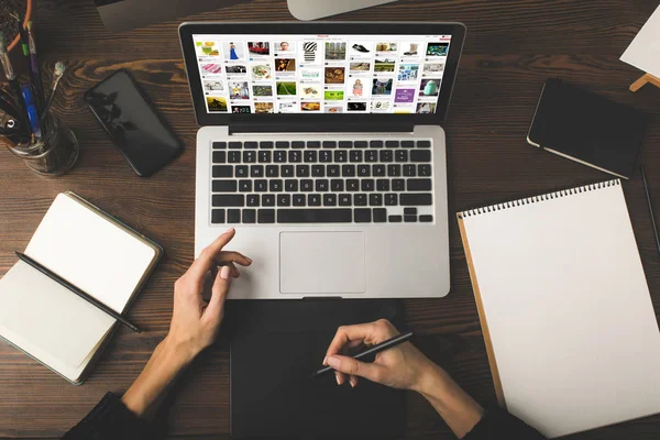Schnappschuss eines Designers mit Grafik-Tablet und Laptop mit pinterest-Website auf dem Bildschirm — Stockfoto