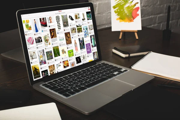 Designer-Arbeitsplatz mit Laptop und Pinterest-Website auf dem Bildschirm — Stockfoto