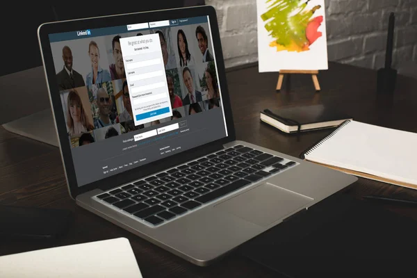 Дизайнер на робочому місці з ноутбуком і linkedin сайт на екрані — стокове фото