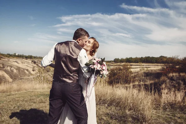 Jonge bruidspaar - vers wo bruidegom en bruid poseren buitenshuis op hun trouwdag (afgezwakt kleurenafbeelding) — Stockfoto