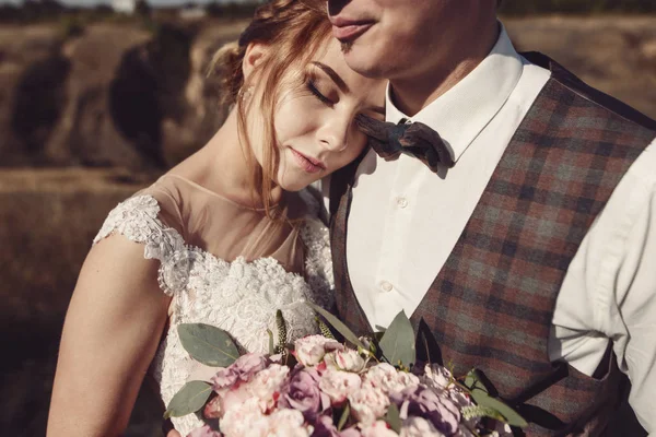 Εκλεκτής ποιότητας πορτρέτο του ένα νεαρό hipster ζευγάρι που θέτουν σε γαμήλια σουίτα και το φόρεμα στο ηλιοβασίλεμα στο δάσος — Φωτογραφία Αρχείου