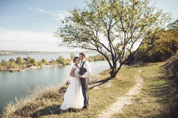 Charmante bruid en elegante bruidegom op landschap van bergen en suset Lake — Stockfoto