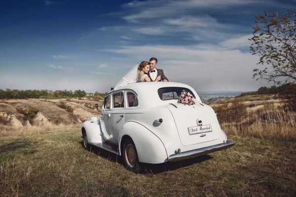 Paar knuffelen op het zonnedak retro auto — Stockfoto