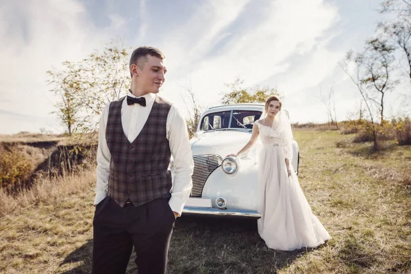 Menyasszony a vőlegény, aki ül egy esküvői retro autó megy. — Stock Fotó