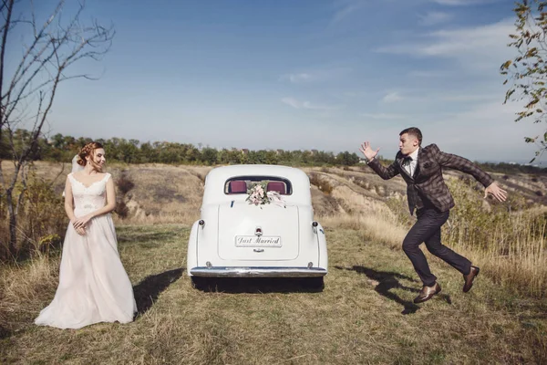 A közelében retro autó, pár esküvő menyasszony menyasszony vőlegény fut — Stock Fotó