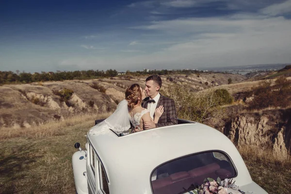 Paar knuffelen op het zonnedak retro auto — Stockfoto