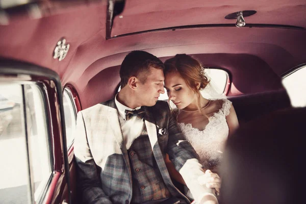 Γαμπρός και νύφη στο πίσω κάθισμα του αυτοκινήτου — Φωτογραφία Αρχείου