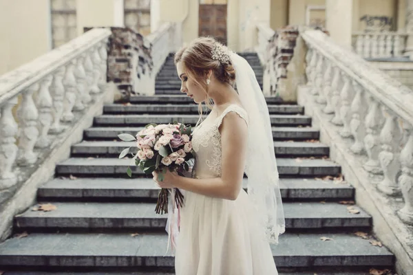 階段に花束立って、笑顔の花嫁. — ストック写真