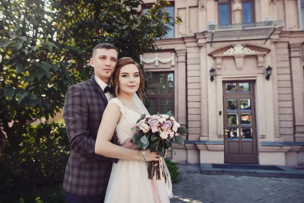 Beau couple nouvellement marié étreignant près de vieux bâtiment baroque château — Photo