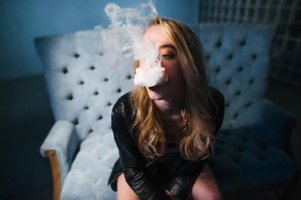 Vaping güzel bir kadındır. Koyu arka plan. Stüdyo çekim. Portre kadar kapatın