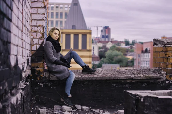 Beautiful young girl sitting on the roof — Stock Photo, Image