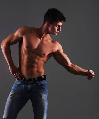 Gömleksiz adam gri arka plan üzerinde poz Jeans gövde