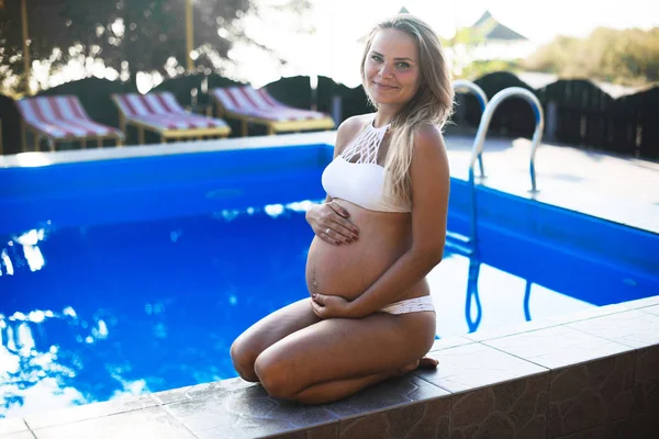 Молодая беременная женщина в бассейне — стоковое фото