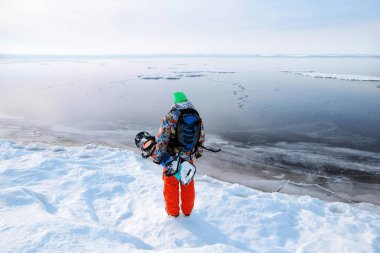 Sporcu donmuş gölün izlerken snowboard ile arka görünümü