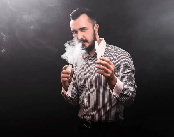 O homem fuma cigarro electrónico. Fumar e vaping em preto — Fotografia de Stock