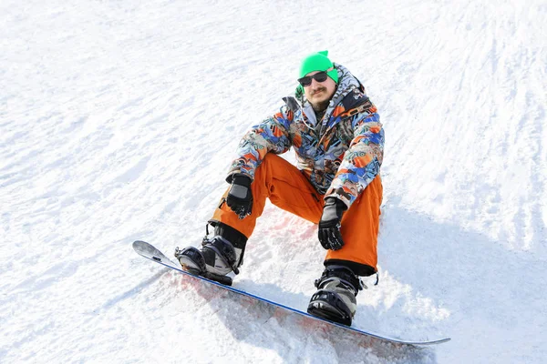 Brodaty snowboardzista jest wysoko w górach — Zdjęcie stockowe