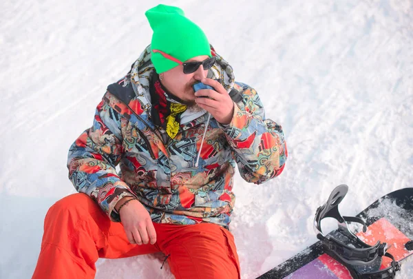 Snowboarder drinking tea in winter — Stock Photo, Image